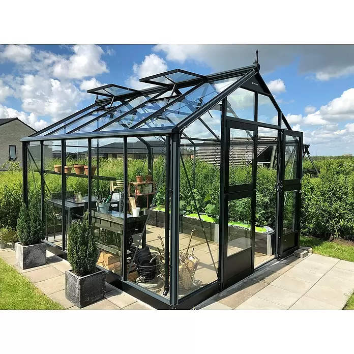 Juliana Gewächshaus Premium - Außenmaß inkl. Dachüberstand (B x T): 296 x 368 cm, 3 mm, Anthrazit, Einscheibensicherheitsglas - Großes schwarzes Glas-Gewächshaus mit offenen Dachlüftungen auf einer gepflasterten Terrasse, für Gartenarbeit und Entspannung.