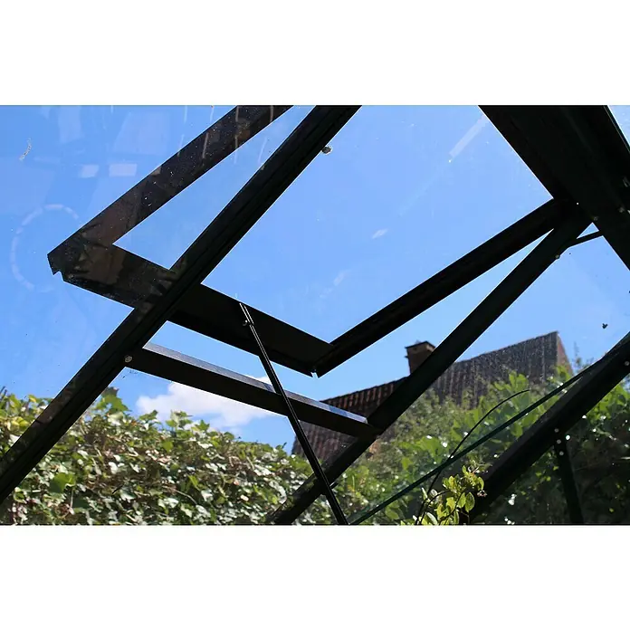 Juliana Gewächshaus Compact - Außenmaß inkl. Dachüberstand (B x T): 224 x 368 cm, Material Seitenwand: Glas, 3 mm, Schwarz - Ein Blick durch das geöffnete Fenster eines Gewächshauses mit schwarzem Rahmen, das einen klaren blauen Himmel und die umliegende Vegetation zeigt.