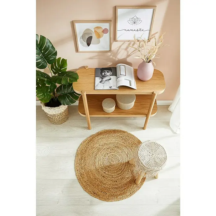 Juteteppich Mala - Natur, Durchmesser: 100 cm, 99 % Jute, 1 % Baumwolle - Nahaufnahme eines stilvollen Wohnzimmers mit einem zweistöckigen Holztisch, einem runden Teppich und dekorativen Accessoires wie Pflanzen und Kunstwerken.
