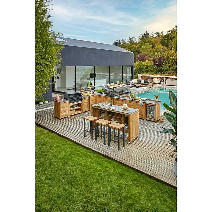 Kingstone KMS Gasgrill Cliff 6005 Beast Built In - Grillfläche (B x T): 90,5 x 45 cm, 21 kW, Anzahl Brenner: 6 Stk. - Ein modernes Outdoor-Küchenset aus Holz mit Grill, Arbeitsflächen und Barhockern auf einer Holzterrasse neben einem gepflegten Garten.