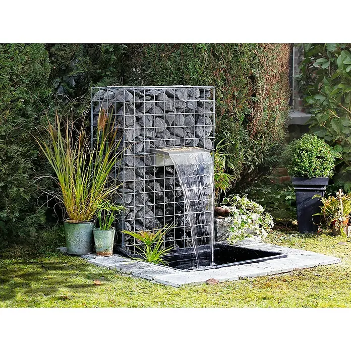 Ubbink Einbau-Wasserfall Niagara LED 30 Set - 12,5 x 30 x 10 cm, Edelstahl, Leuchtmittel: LED - Ein Gabionenbrunnen mit Wasserfall im Garten, umgeben von Pflanzen und Grünflächen. Ein dekoratives Highlight für jeden Außenbereich.