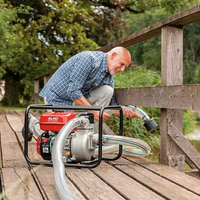 AL-KO Schmutzwasserpumpe - 4,1 kW, Max. Fördermenge: 30.000 l/h, Eintauchtiefe: 6 m - Ein Mann bereitet eine AL-KO BMP 30000 Wasserpumpe für den Einsatz vor, indem er den Schlauch ins Wasser lässt.