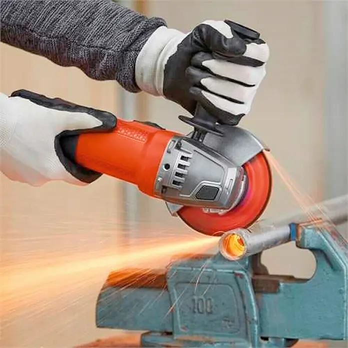 Black+Decker Amoladora angular eléctrica BEG110 - 750 W, 115 mm - Primer plano de una amoladora angular en acción, cortando una tubería de metal con chispas.