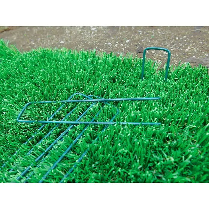 Grapa metálica Fixsol - 10 ud. - Primer plano de grapas de césped verde azulado y malla de alambre sobre césped verde, ideal para proyectos de jardinería y paisajismo.