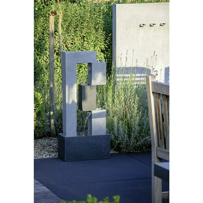 Dobar Gartenbrunnen - 40,5 x 21,5 x 90,5 cm, Kunststoff, Grau - Gartenszene mit einem modernen, mehrstufigen Wasserbrunnen aus Stein, der einen beruhigenden Mittelpunkt im Außenbereich bildet.