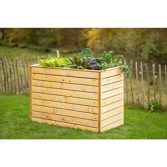 Westmann Hochbeet Asket L - 70 x 130 x 90 cm, Holz, Natur - Dieses Bild zeigt einen hölzernen Pflanzkasten voller Salat, Kohl und Grünzeug in einem üppigen Garten, umgeben von einem rustikalen Zaun.