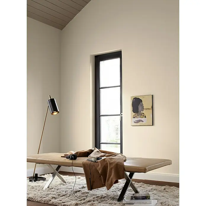 Alpina Wandfarbe Feine Farben - Vers in Pastell, Matt, 2,5 l, Konservierungsmittelfrei - Beige Liege mit Metallgestell, ergänzt durch eine Stehlampe und Kunstwerk an der Wand, die ein stilvolles Interieur zeigt.