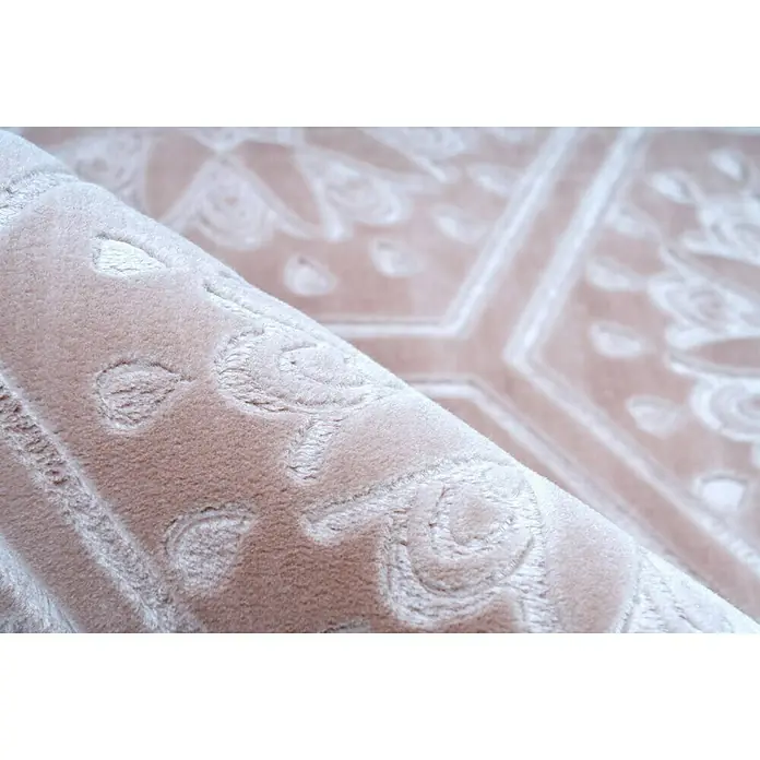 Kayoom Kurzflorteppich Monroe II - Rosa, 230 x 160 cm, 100 % Polyester - Nahaufnahme eines gerollten Teppichs mit floralen Mustern. Das beige Farbschema und die Textur des Teppichs sind gut sichtbar.
