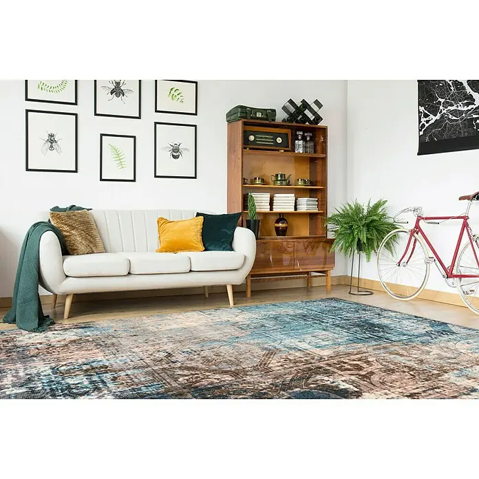 Kayoom Kurzflorteppich Indiana - Blau/Braun, 150 x 80 cm, 100 % Baumwolle - Wohnzimmer mit stilvollem Teppich, Sofa, Bücherregal und Fahrrad. Der Teppich verleiht dem Raum eine warme und einladende Atmosphäre.
