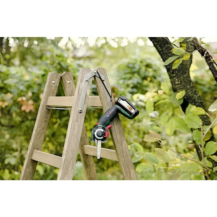 Bosch Power for All 18V Sierra NanoBlade AdvancedCut 18 - Número de revoluciones de marcha en vacío: 7.000 r.p.m., 18 V, 1 batería - Sierra de jardín inalámbrica Bosch sobre una escalera de madera en el jardín. Ideal para podar árboles y hacer jardinería.