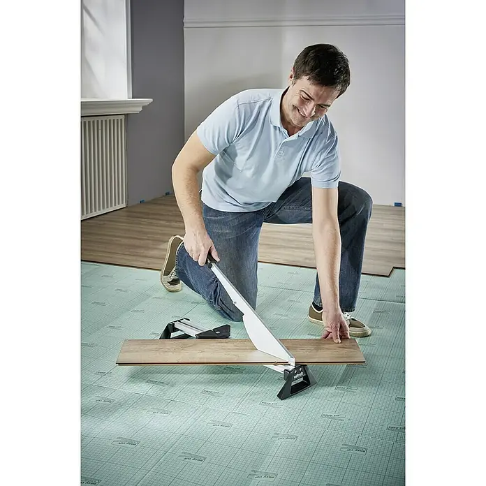 Wolfcraft Cortaláminas de parquet LC 600 - Ancho de corte: 465 mm, Aluminio - Un hombre corta laminado con una cortadora de laminado Wolfcraft. La herramienta permite cortes precisos para una fácil instalación del suelo.