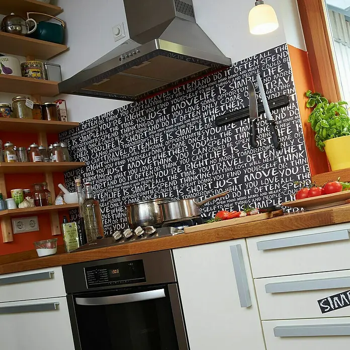 A.S. Création Designpanel pop.up - Schwarz, 35 cm x 2,5 m - Küchendetails mit Dunstabzugshaube, Herd, Gewürzen und Deko an der Wand.