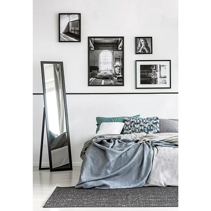 Standspiegel Tina - 40 x 160 cm, Schwarz, Holz - Gemütliches Schlafzimmer mit großem Spiegel, grau-blauer Bettwäsche und einer Auswahl an gerahmten Kunstdrucken an der Wand.