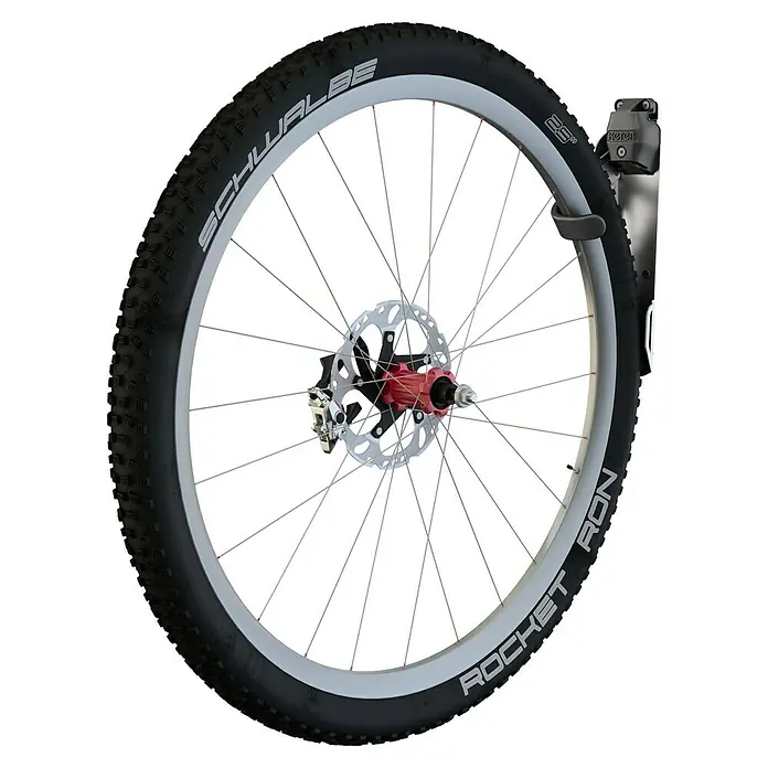 Keter Soporte de pared de bicicletas - Específico para: Caseta Keter - Primer plano de una llanta de bicicleta Schwalbe Rocket Ron, montada en un soporte de pared. Perfecto para almacenamiento.