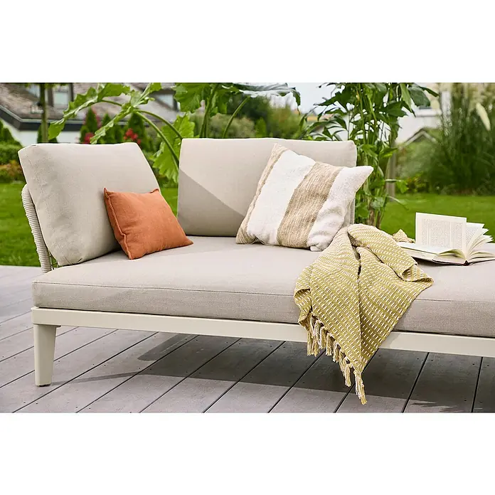 Sunfun Solo Rope Lounge-Ottomane - Light-Greige, Metall - Nahaufnahme eines Outdoor-Daybeds mit hellen Kissen und einer gelben Decke, ideal zum Entspannen im Garten.