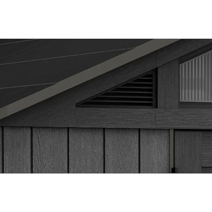 Keter Gerätehaus Stronghold 10x8 - Außenmaß inkl. Dachüberstand (B x T): 304 x 243 cm, Kunststoff, Grau - Nahaufnahme eines dunklen Gartenhauses mit Holzverkleidung, Lüftungsgitter und einem Fenster. Die Bauweise ist modern und ansprechend.