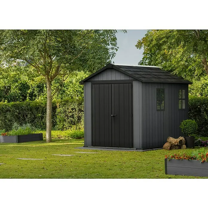 Keter Gerätehaus Newton Plus 759 - Außenmaß inkl. Dachüberstand (B x T): 230 x 287 cm, Kunststoff, Schiefergrau - Das Bild zeigt ein graues Gartenhaus mit Doppeltür, Fenstern und einem dunklen Dach in einer grünen Gartenumgebung.