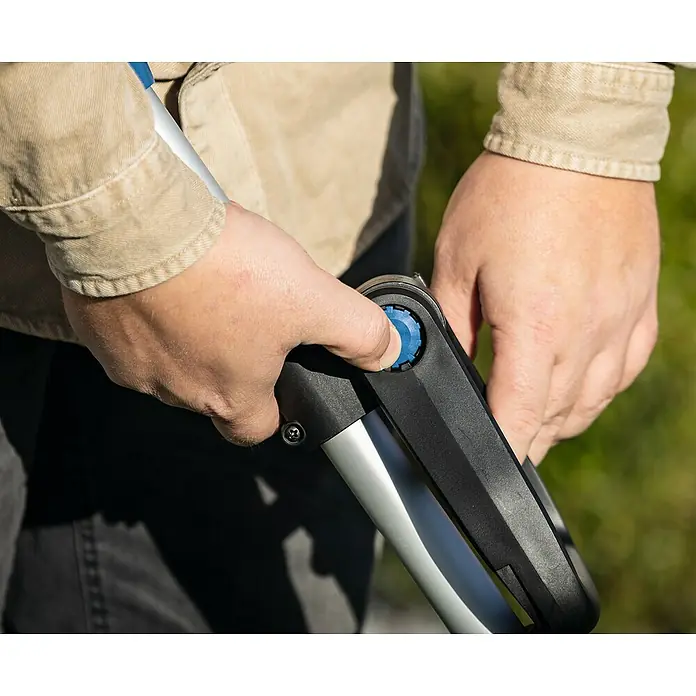 Scheppach IXES 20V Akku-Rasentrimmer C-LT300-X Set S - 20 V, 2 Ah, Li-Ionen, 1 Akku, Schnittbreite Faden: 300 mm - Nahaufnahme einer Person, die einen blauen Knopf an einem verstellbaren Werkzeuggriff drückt.