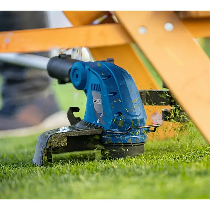 Scheppach IXES 20V Akku-Rasentrimmer C-LT300-X Set S - 20 V, 2 Ah, Li-Ionen, 1 Akku, Schnittbreite Faden: 300 mm - Nahaufnahme eines blauen Rasentrimmers im Einsatz, der Gras schneidet. Das Gerät ist von hoher Qualität und ideal für Gartenarbeiten.