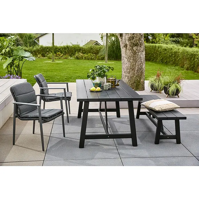 Sunfun Gartenmöbel-Set Melina/Solo - 6 -tlg., Akazie/Aluminium/Kunststoff, Black Washed/Night-Grey - Ein stilvolles Outdoor-Set mit einem dunklen Esstisch, zwei Stühlen mit Polstern und einer Bank mit Kissen auf einer gepflasterten Terrasse.