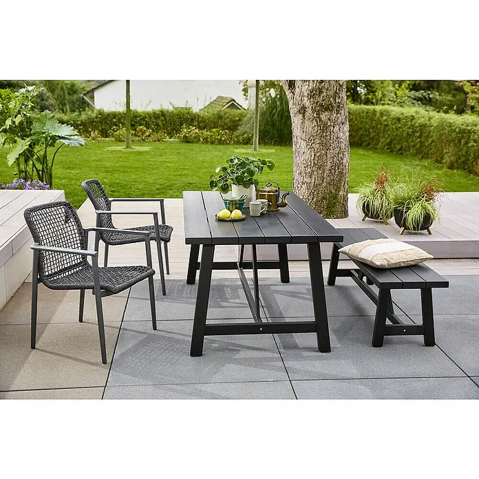 Sunfun Gartenmöbel-Set Melina/Solo - 4 -tlg., Akazie/Aluminium/Kunststoff, Black Washed/Night-Grey, Gartenstuhl stapelbar - Ein Esstisch-Set für den Außenbereich mit zwei Stühlen und einer Bank auf einer gepflasterten Terrasse, umgeben von Grün.