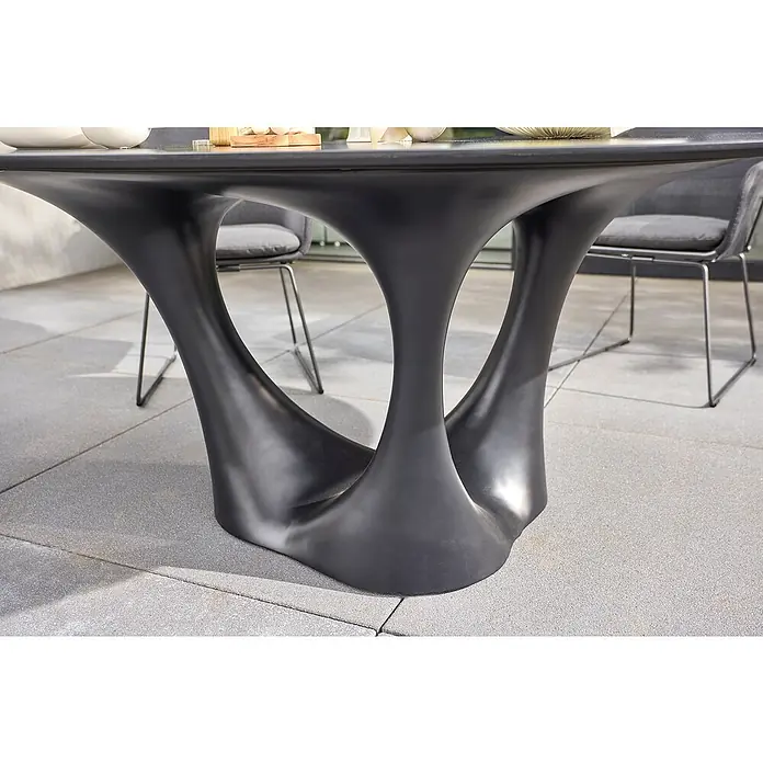 Sunfun Gartenmöbel-Set Black Series/Sarah - 6 -tlg., Schwarz/Night-Grey, Stapelbar - Detailaufnahme eines modernen Esstisches mit einem einzigartigen, skulpturalen Untergestell in dunkler Farbe und Stühlen im Hintergrund.