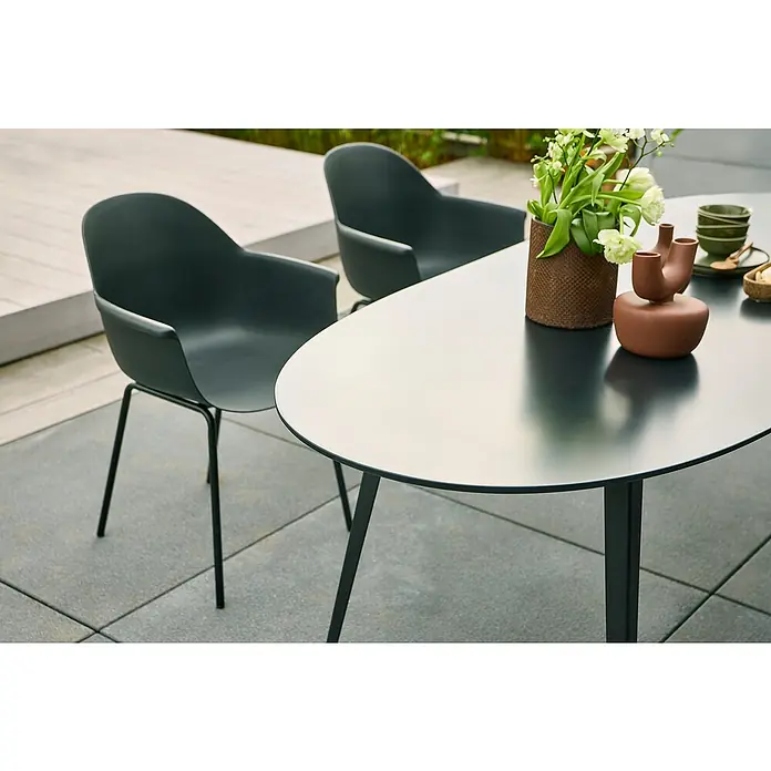 Gartentisch Black Series - L x B x H: 210 x 90 x 74 cm, Verbundwerkstoff, Schwarz - Zwei graue Esszimmerstühle und ein ovaler Tisch mit Dekoration darauf. Die Stühle haben eine geschwungene Rückenlehne und schlanke Beine.