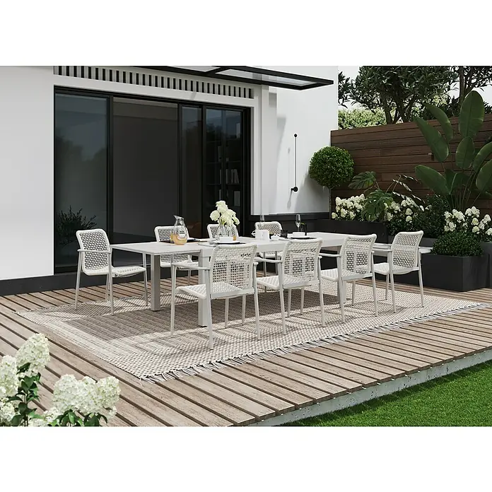 Sunfun Solo Silla de jardín - 67 x 63 x 85 cm, Beige, Aluminio/Olefina, Apilable - Un elegante juego de comedor blanco para exteriores con sillas de mimbre sobre una alfombra, perfecto para reuniones al aire libre.