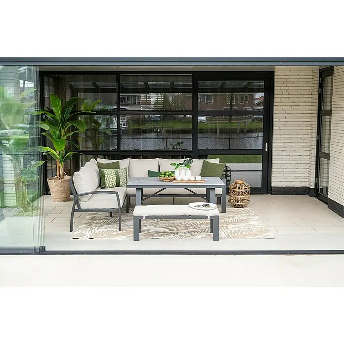Garden Impressions Loungemöbel-Set Vasano - 4 -tlg., Aluminium, Keramik, Polyester, Links, Schwarz/Beige - Ein stilvolles Outdoor-Sitzensemble mit Sofa, Sessel, Tisch und Bank auf einem Teppich, ergänzt durch Pflanzen und Dekorationen.