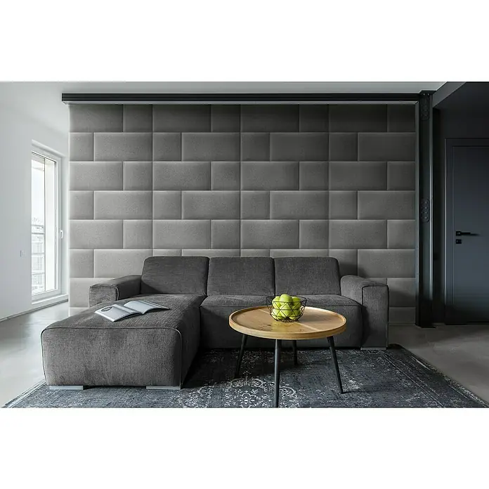 Fllow Wandpolster Inari - Grau, L x B: 30 x 30 cm - Elegante Wohnzimmeransicht mit einem grauen Sofa, einem Couchtisch mit Äpfeln und einer Akzentwand mit gepolsterten Paneelen.
