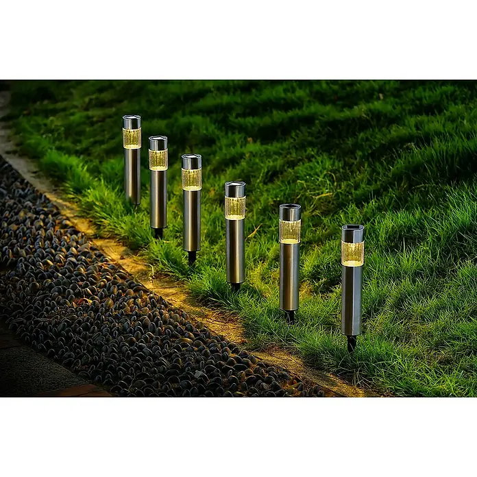 BAUHAUS Solarleuchten-Set Mini - L x B x H: 4,7 mm x 4,7 cm x 33,5 mm, Edelstahl, IP44 - Eine Reihe von Solarleuchten beleuchtet einen Gartenweg mit dunklen Kieselsteinen und saftigem Gras. Die Leuchten sind aus Metall und Glas.