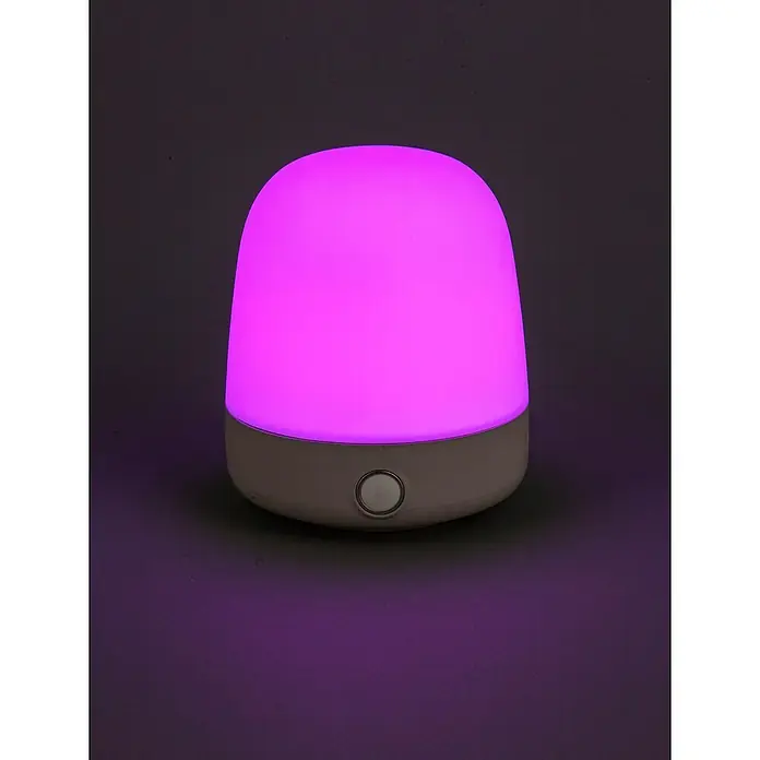Starlux Akku-Tischleuchte Mini - L x B x H: 10 x 10 x 12 cm, Beige, RGBW, 0,3 W, IP44 - Das Bild zeigt eine Nachttischlampe mit einem weichen, pinkfarbenen Licht, die eine beruhigende Atmosphäre erzeugt. Die Lampe ist schlicht und modern gestaltet.