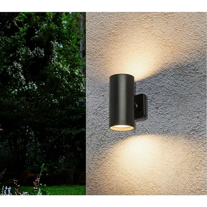 Starlux Akku-Wandleuchte Avio - 2,6 W, 7,1 x 5,3 x 11 cm, IP44, Schwarz - Diese Aufnahme zeigt eine moderne, zylindrische Wandleuchte aus schwarzem Metall, die warmes Licht abstrahlt und eine gemütliche Atmosphäre schafft.