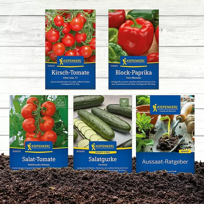Kiepenkerl Saatgut Bundle Unsere Lieblinge - Mischung, 6 Stk. - Sortiment von Kiepenkerl Gemüsesamen-Päckchen (Tomaten, Paprika, Gurken) und einem Aussaat-Ratgeber, auf dunkler Erde präsentiert.