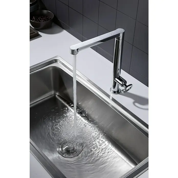 Imex Olimpo Grifo de cocina - Cromo, Resplandeciente - Primer plano de un fregadero de acero inoxidable con un moderno grifo cromado que deja correr el agua. Diseño elegante para la cocina.