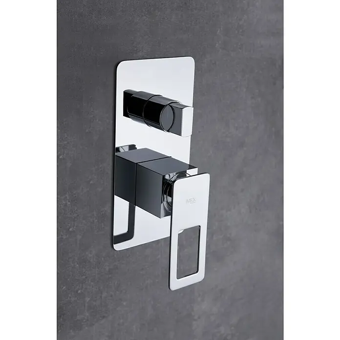 Imex Suecia Sistema de ducha empotrado - Con grifo monomando, Cromo - Primer plano de un moderno grifo IMEX con un acabado cromado brillante y un diseño minimalista montado en una pared gris.