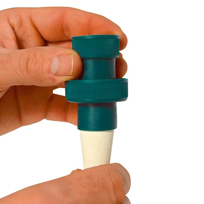 Sistema de irrigación con tubo - Plástico, 4 pzs. - Primer plano de una mano que sostiene un cono de riego para plantas, ofreciendo una hidratación lenta y constante.