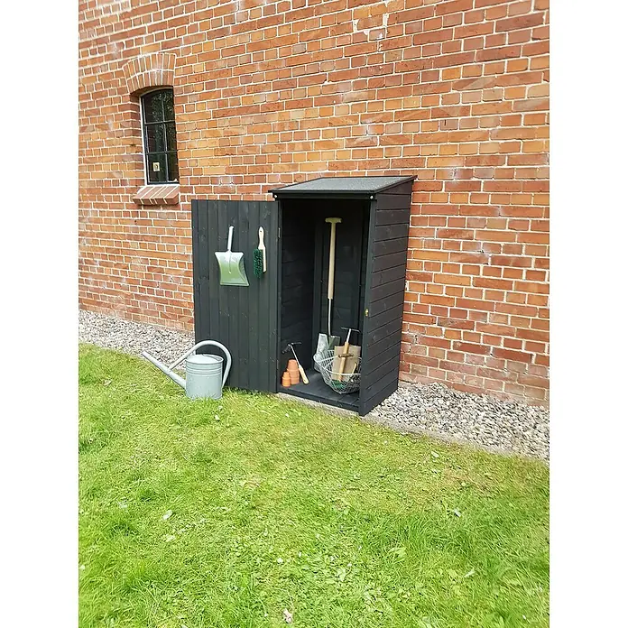Promadino Geräteschrank Speyer - Holz, Anthrazit - Ein schwarzer Gartenschrank aus Holz, an einer Backsteinmauer platziert, bietet Stauraum für Gartengeräte und Zubehör.
