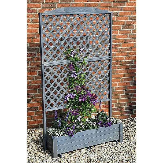 Promadino Pflanzkasten Romantica - Außenmaß (L x B x H): 210 x 38 x 120 cm, Holz, Grau - Grauer Pflanzkasten mit Spalier und lila Blüten vor einer Ziegelmauer auf Kies. Ideal für Garten oder Terrasse, dekorativ und praktisch.