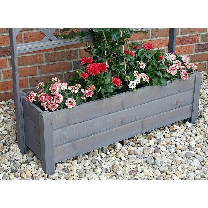 Promadino Pflanzkasten Botanica - Außenmaß (L x B x H): 140 x 32 x 110 cm, Holz, Grau - Ein grauer Pflanzkasten aus Holz mit bunten Blumen, der auf einem Kiesweg vor einer roten Backsteinmauer steht.