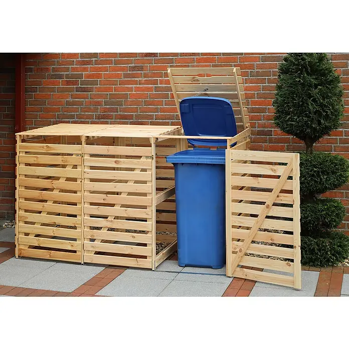 Promadino Mülltonnenbox Vario V -  - Eine hölzerne Mülltonnenbox mit zwei Fächern, einer blauen Mülltonne und einem geöffneten Deckel vor einer roten Backsteinmauer und einer Thuja.
