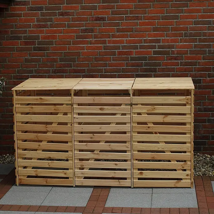 Promadino Mülltonnenbox Vario V -  - Das Bild zeigt drei hölzerne Mülltonnenboxen mit Klappdeckeln und horizontalen Latten vor einer roten Backsteinmauer.