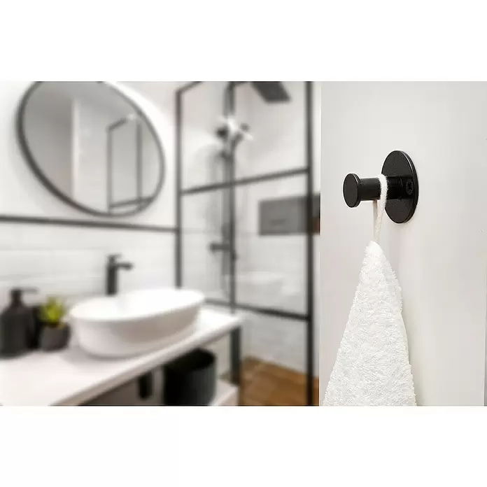 Rei Garderobenhaken C8714 - L x B x H: 40 x 52 x 52 mm, Stahl, Schwarz - Ein schwarzer Wandhaken hält ein weißes Handtuch in einem modernen Badezimmer.