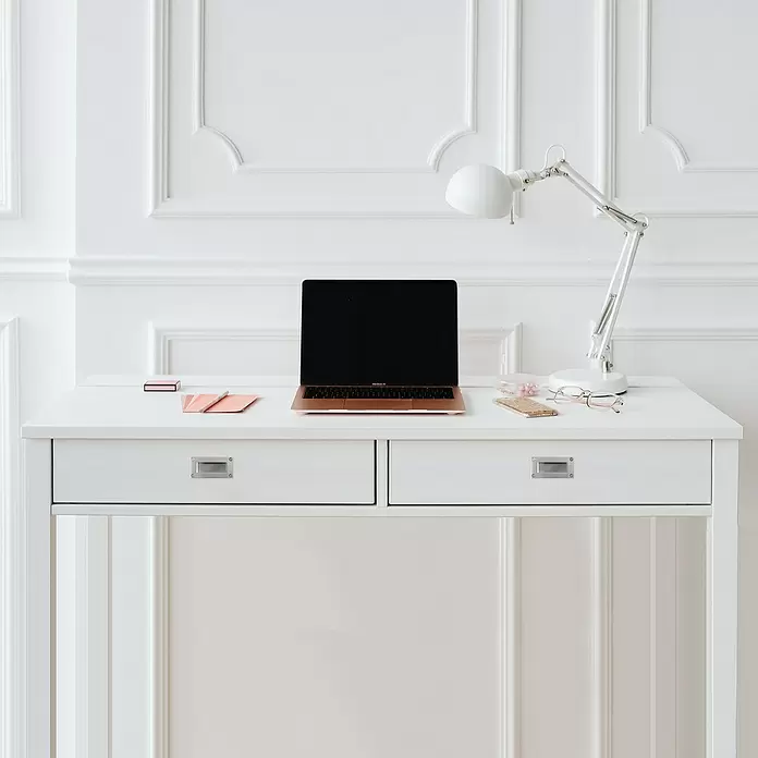 Rei Möbelgriff - Lochabstand: 96 mm, Sonstige, Edelstahl - Ein weißer Schreibtisch mit einem roségoldenen Laptop, einer weißen Lampe und anderen kleinen Gegenständen.