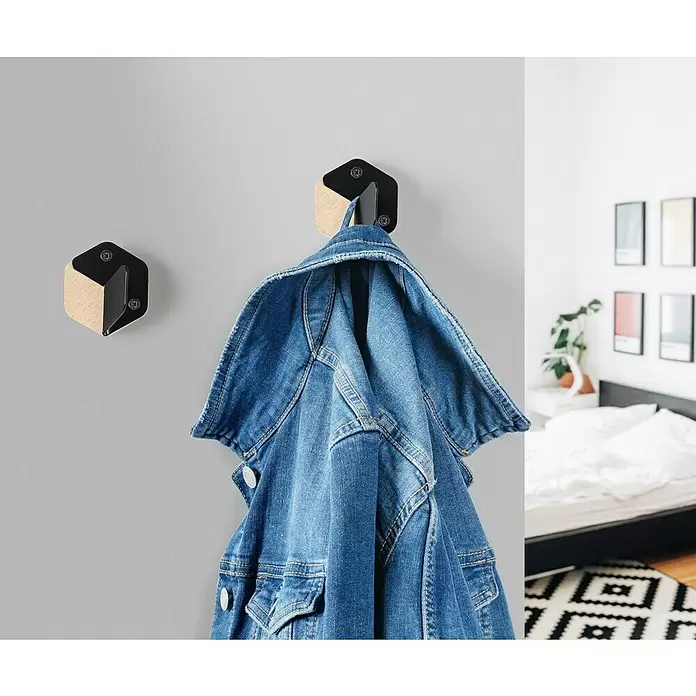 Rei Garderobenhaken C8715 - L x B x H: 40 x 61 x 66 mm, Holz, Schwarz - Hexagonale Wandhaken aus Holz und schwarzem Metall. Einer hält eine Jeansjacke, ein weiterer leerer Haken ist an der Wand.