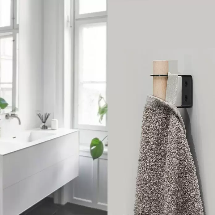Rei Garderobenhaken C8710 - L x B x H: 55 x 28 x 66 mm, Holz, Schwarz - Ein Handtuchhaken aus Naturholz und schwarzem Metall mit einem grauen Handtuch, an einer Wand in einem modernen Badezimmer.