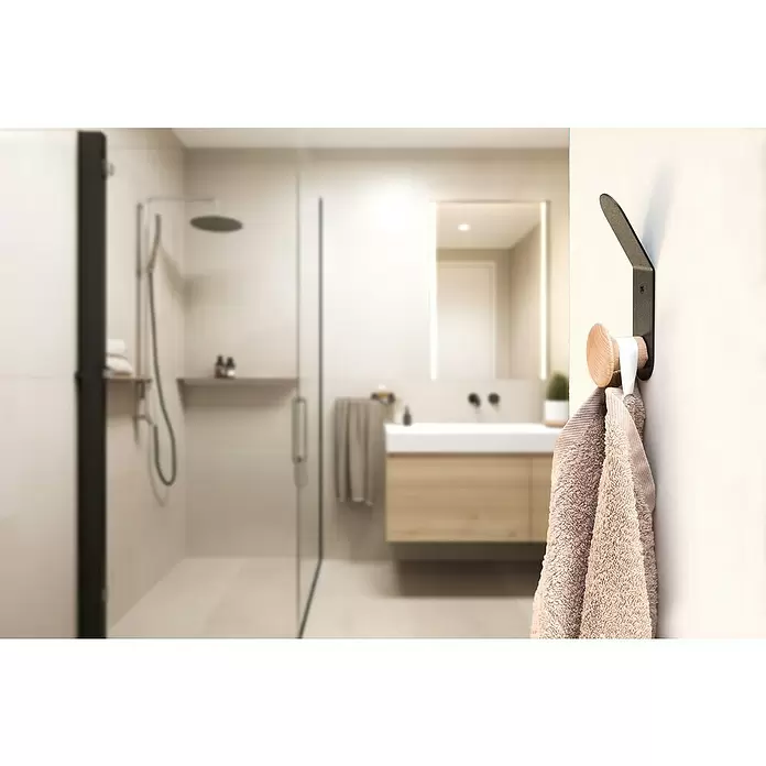 Rei Garderobenhaken C8713 - L x B x H: 37 x 45 x 135 mm, Holz, Schwarz - Moderner Handtuchhaken aus schwarzem Metall und Holz, der ein beiges Handtuch in einem modernen Badezimmer hält.