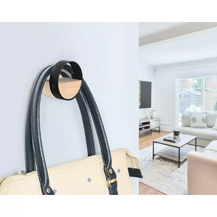 Rei Garderobenhaken C8704 - L x B x H: 40 x 50 x 50 mm, Holz, Schwarz - Moderner Wandhaken aus Holz und schwarzem Metall, der eine Handtasche im hellen Wohnzimmer hält.