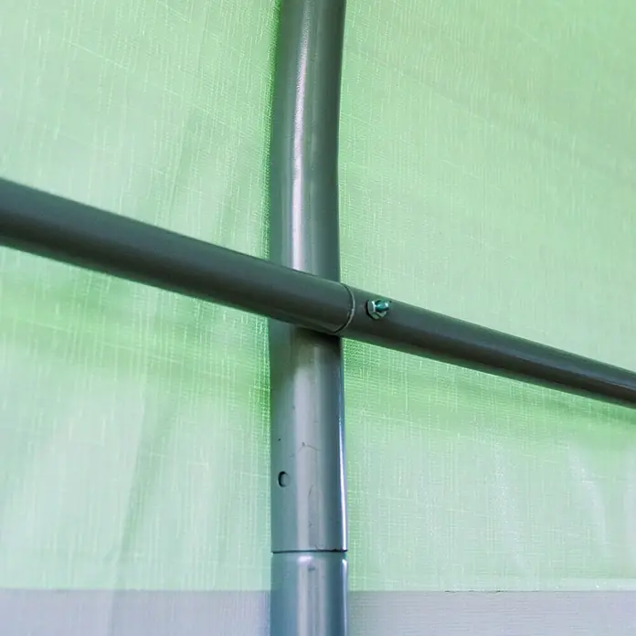 ShelterLogic Gerätehaus - Außenbreite inkl. Dachüberstand: 240 cm, Außentiefe inkl. Dachüberstand: 240 cm, Stahl, Grün - Nahaufnahme eines grünen Gewächshausrahmens aus Metallrohren, verbunden mit einer Schraube vor einem grünen Hintergrund.