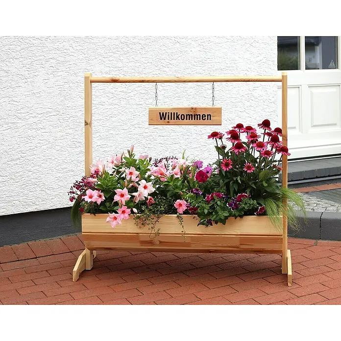 Promadino Pflanzkasten Willkommen - Außenmaß (L x B x H): 103 x 40 x 110 cm, Holz, Braun - Blumenkasten aus Holz mit dem Wort "Willkommen" darauf, gefüllt mit einer Vielfalt von Blumen in Rosa- und Rottönen.